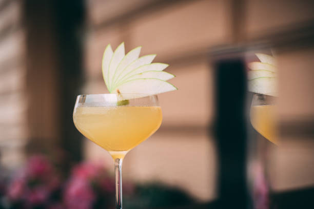 appletini cocktail serviert mit frischer apfelgarnitur auf der oberseite - apple martini stock-fotos und bilder