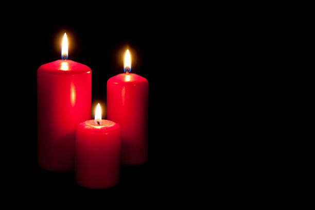 istock Set of three red candles burning in the dark 136629649