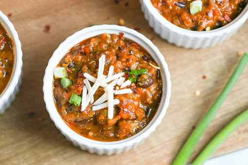 Vegan chili topped with cheese and scallions