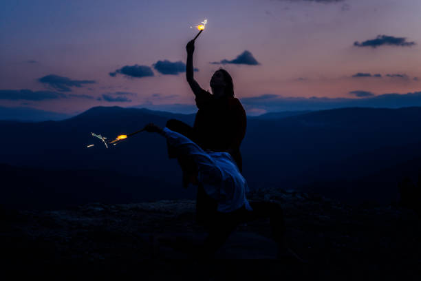 istock Modern style dancers posing on mountain against sunset sky 1366298915