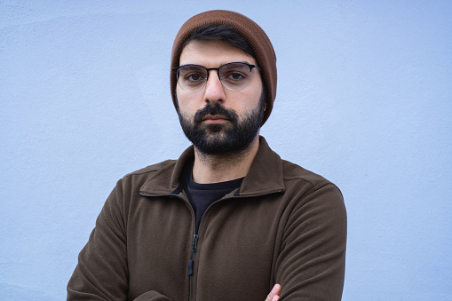 Young man isolated on blue textured wall.