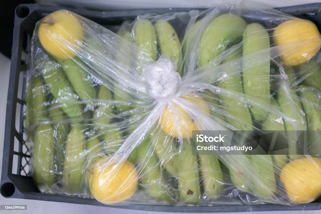 Natural ripening of bananas in the crate with apples Agriculture Stock Photo