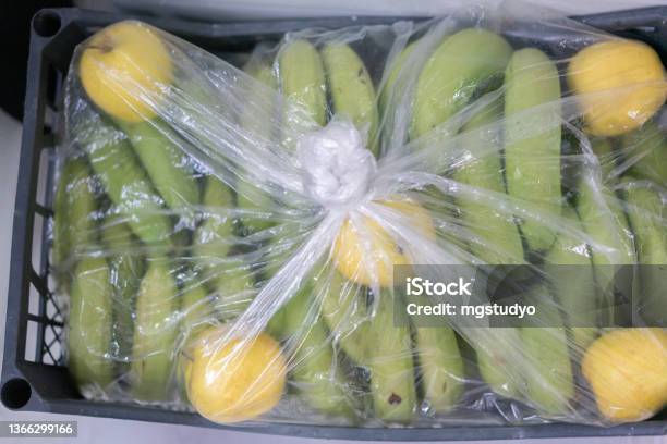 Natural Ripening Of Bananas In The Crate With Apples Stock Photo - Download Image Now