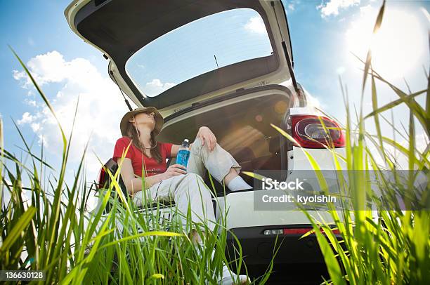 Foto de Jovem Mulher Descansando No Carro e mais fotos de stock de Azul - Azul, Carro, Céu - Fenômeno natural