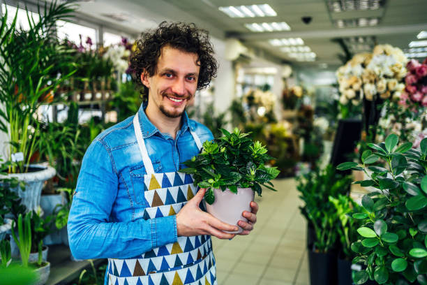 istock Florist man holding potted plant 1366304938