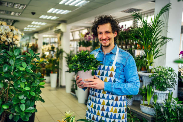 istock Florist man holding potted plant 1366307414