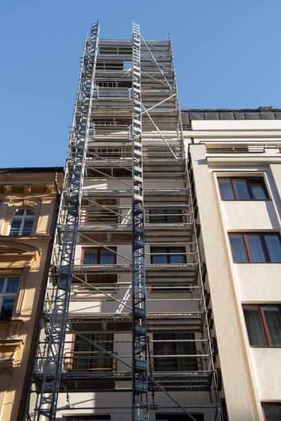 istock Construction freight elevator attached to the renovated european building. Construction site work equipment 1366311885