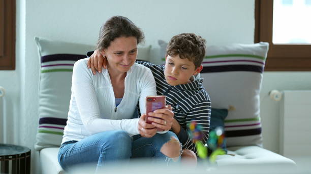 istock Mother and child sitting together watching content on phone 1366317968