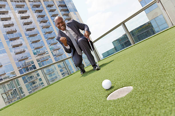 アフリカ系アメリカ人のビジネスマンゴルフ屋上の超高層ビル - golf golf course putting men ストックフォトと画像