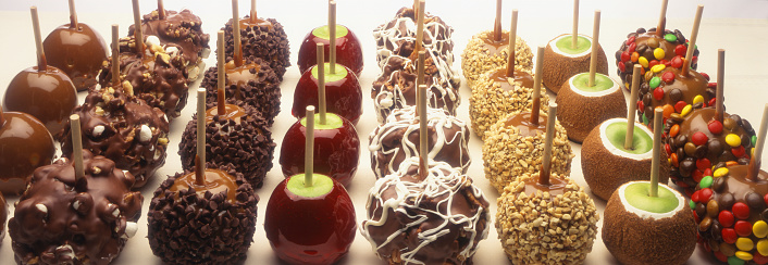Several rows of different types of candy apples.
