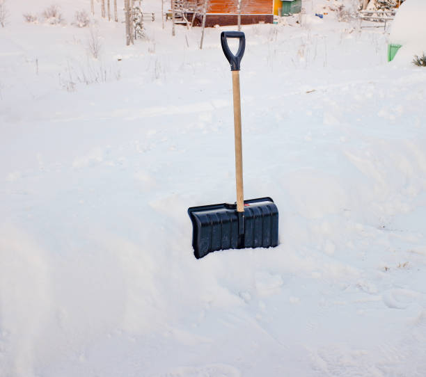 istock a black plastic shovel with a wooden handle stuck in fluffy white snow 1366322484