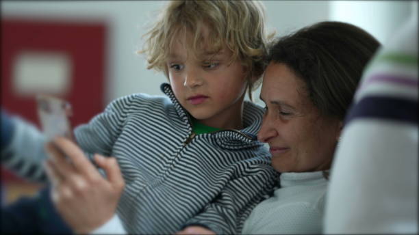 istock Mother and child sitting together watching content on phone 1366322552