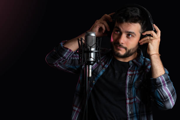 istock young man recording in recording studio. 1366323531