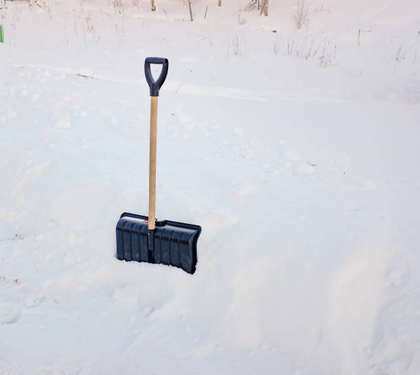 istock a black plastic shovel with a wooden handle stuck in fluffy white snow 1366323580