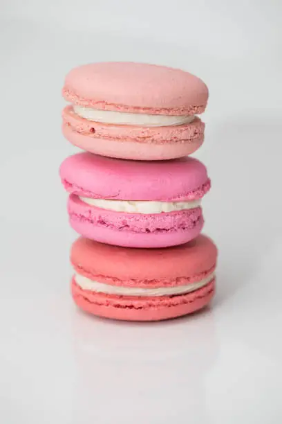 Close up of pink macarons on white background