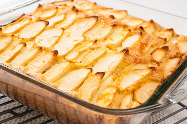 istock Fresh baked apple cake with biscuit base close up in glass baking dish on kitchen table 1366340978