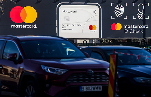 Bucharest, Romania - January 04, 2022: A MasterCard advertisement is displayed on a sign above a large car park in Bucharest.