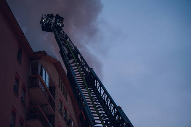 istock Firefighter on pull-out crane put out a fire in a burning building 1366344064