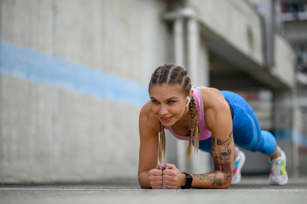 istock Attractive young woman in a plank position while training outside 1366344098