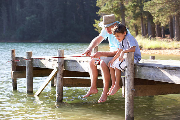 senior homme pêche avec petit-fils - fishing lake grandfather grandson photos et images de collection