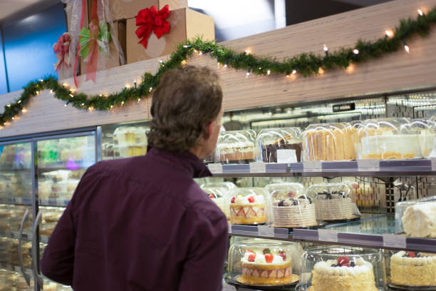 Man in Grocery Store Shopping for Cakes stock photo