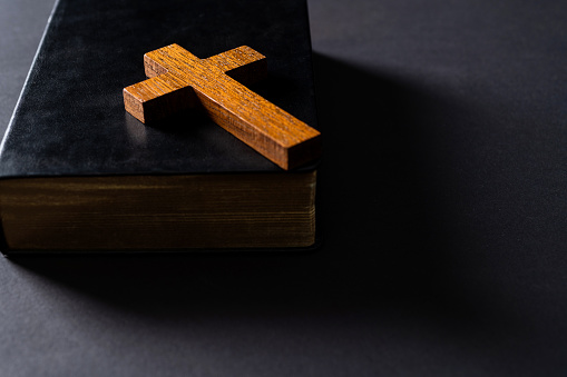 Wooden cross on bible cover.