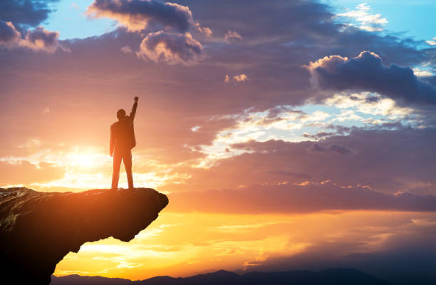 istock Businessman standing on the top of rock 1366352000