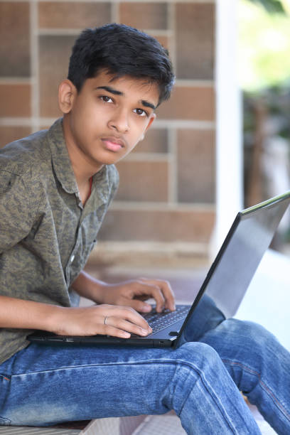 istock Portrait of Indian boy using laptop while attending the online classes at home 1366357008