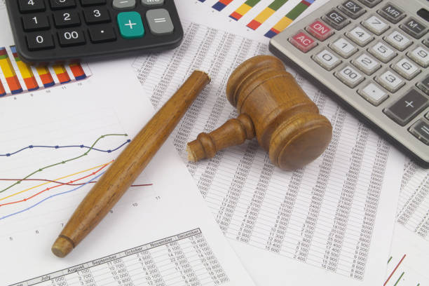 istock Broken judge gavel on calculator isolated on white background. 1366360306