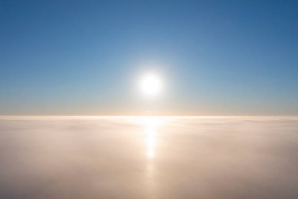 Aerial view white clouds in blue sky. View from drone. Aerial top view cloudscape. Texture of clouds. View from above. Sunrise or sunset over clouds. Airplane view