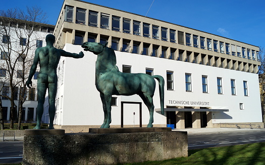 Entrance to the main building of Technical University of Munich, TUM, 1928 bronze sculpture Horse Tamer by Hermann Hahn in the foreground, Munich, Germany