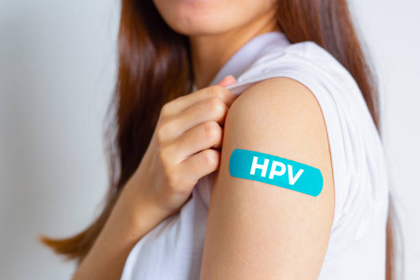 HPV (Human Papillomavirus) Teenager woman showing off an blue bandage after receiving the HPV vaccine.viruses Some strains infect genitals and can cause cervical cancer. Woman health concept. HPV (Human Papillomavirus) Teenager woman showing off an blue bandage after receiving the HPV vaccine. viruses Some strains infect genitals and can cause cervical cancer. Woman health concept. human papilloma virus photos stock pictures, royalty-free photos & images