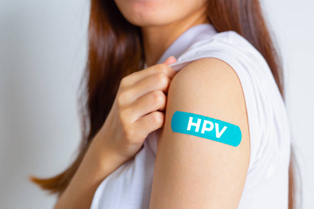 hpv (human papillomavirus) teenager woman showing off an blue bandage after receiving the hpv vaccine.viruses some strains infect genitals and can cause cervical cancer. woman health concept. - medicine dose medical medicine and science imagens e fotografias de stock