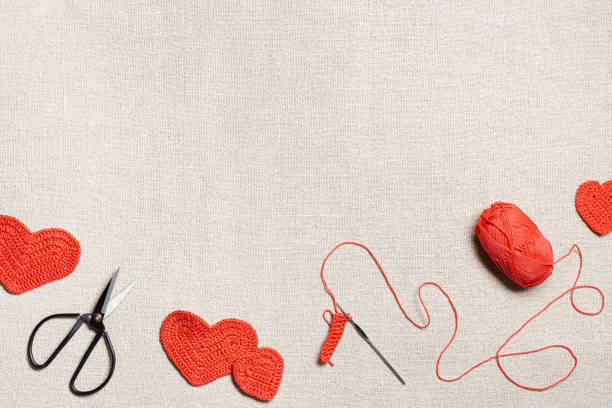 Valentines day concept, preparation knit hearts valentine, handmade red crochet heart, hook, yarn on table, knit work creatives, homely hobby, diy gift for romance holiday. Top view, copy space concepto de día de san valentín, preparación corazones de punto san valentín, corazón de ganchillo rojo hecho a mano, gancho, hilo en la mesa, creativos de trabajo de punto, pasatiempo hogareño, regalo de bricolaje para vacaciones románticas. vista