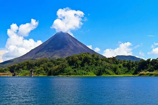 Arenal Volcano 'puffs' out a cloud above the rainforest on the shores of Lake Arenal in Costa Rica