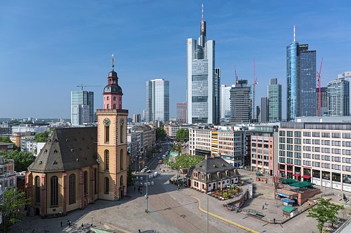 Frankfurt am Main, Germany - May 12, 2018: Hauptwache square with St. Catherine's Church and the Hauptwache building (former guard-house) on the background of skyscrapers of Bankenviertel (financial district).
