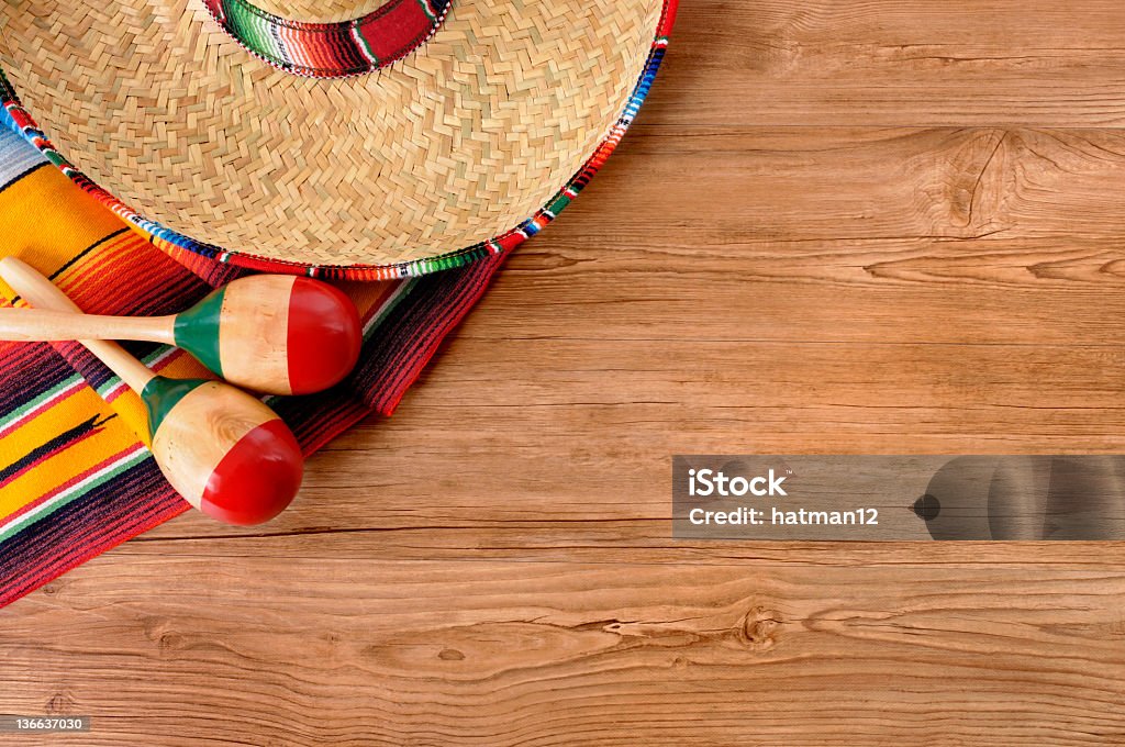 Mexican sombrero and blanket on pine wood floor Mexican background with traditional serape blanket, sombrero and maracas on a pine wood floor with copyspace.  You can see my complete Mexican collection by CLICKING HERE.  Alternative version of this picture with sand and copyspace shown below: Mexican Culture Stock Photo