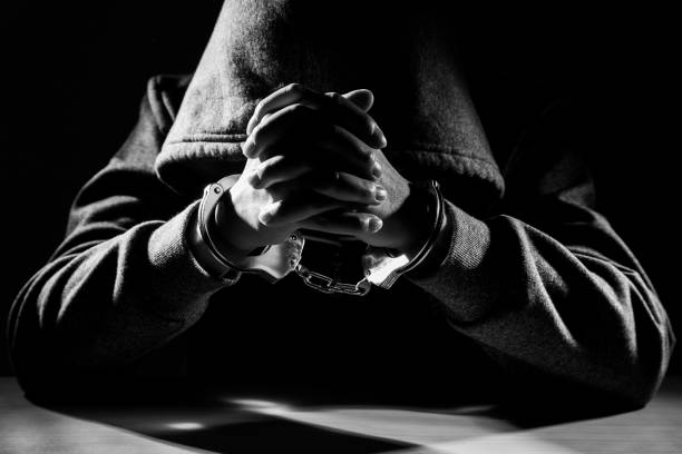 istock Arrested criminal hands locked in handcuffs. 1366372869