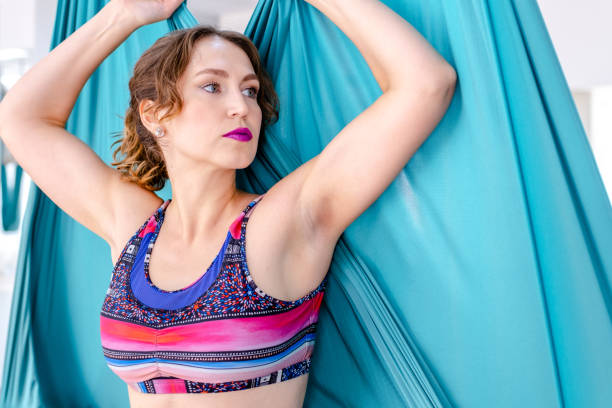 istock attractive young woman doing antigravity yoga using blue hammock in studio 1366373284