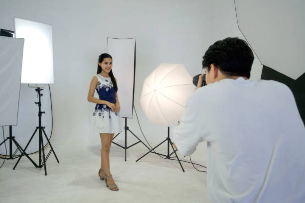istock Young asian photographer is photographing a model posing in the studio. 1366373956