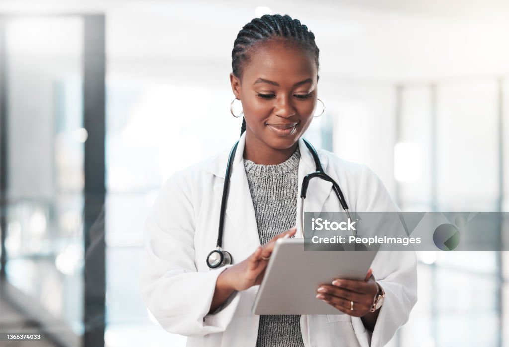 Shot of a young doctor using a digital tablet in a modern hospital Who has time to be tied down to a desk? Doctor Stock Photo