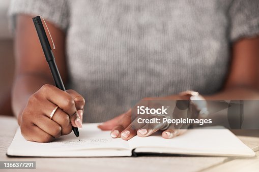 istock Shot of an unrecognisable businesswoman making notes in a book in a modern office 1366377291