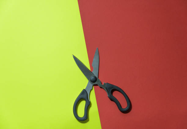 istock Scissors cut paper background. yellow and red 1366379214