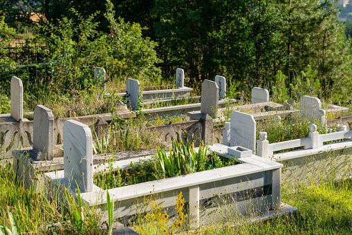 Calgary, Alberta, Canada â October 9, 2022: Tombstones in a Chinese graveyard on the hill in Calgary with a blue sky in the background