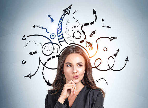 Businesswoman thinking, arrows with different direction, difficult choice Office woman in black jacket thinking hard, hand to chin. Black arrows drawn on blue wall, multiple direction. Concept of decision making and career development brainstorming stock pictures, royalty-free photos & images