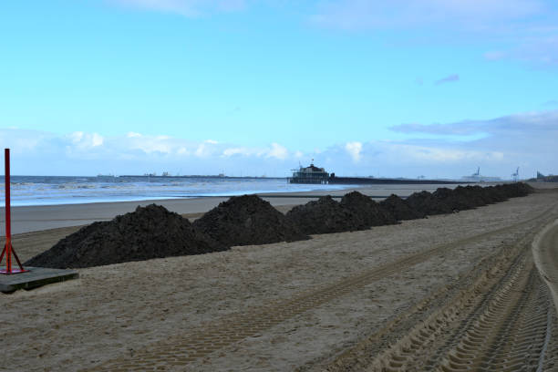 istock Beach nourishment. Reconstructing the beach profile after heavy storm. Adding sand 1366384394