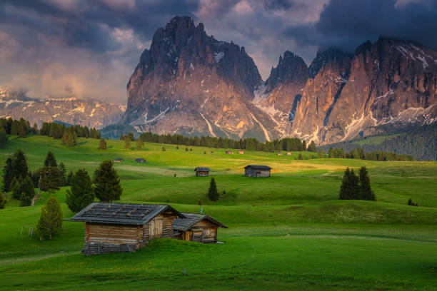 istock Spring alpine landscape and wooden chalets on the fields, Dolomites 1366387853