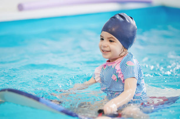 istock Girl ride board in swimming pool 1366389778