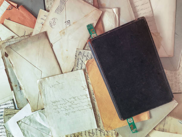 istock Vintage black leather journal on top of scattered old letters and documents 1366389839