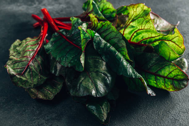 istock Fresh raw leaves of chard on a black stone bacground 1366391730